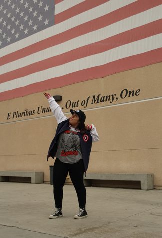 Marvel fan, Daisy Lopez, 11, shows full patriotism by doing a heroic pose in the back of B building with the American flag behind her while wearing Captain America apparel on May 10. “My favorite scenes from the movies are battle [or] fight scenes, I love watching characters go all out with their powers, weapons, and gadgets,” Lopez said. 